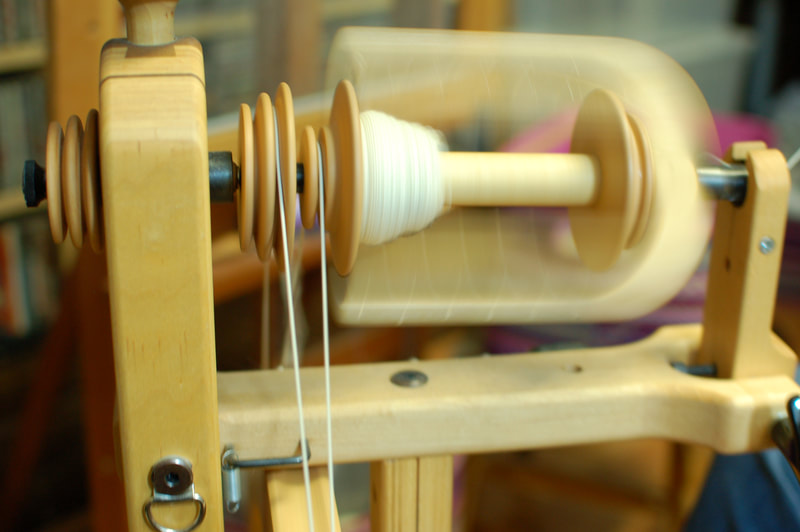 a photo taken at a native american artist's studio. The picture is of thread being spun to be used for traditional native american art weaving. 